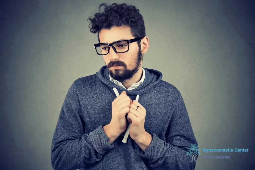 a man wearing layers of clothes to hide unilateral gynecomastia - Unilateral Gynecomastia vs Bilateral Gynecomastia