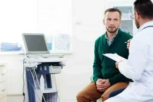 A doctor is consulting with an out-of-town patient in a doctor's office.