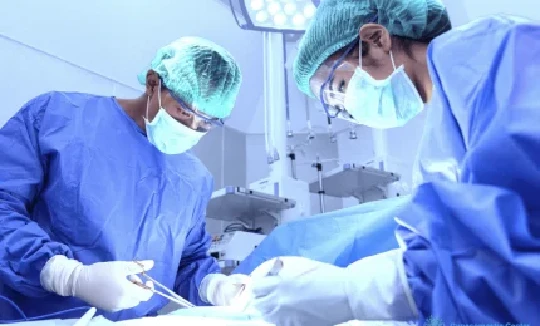 Two surgeons performing surgery in an operating room.