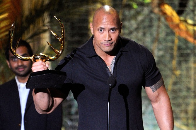 The rock accepts an award at the Emmy Awards alongside other celebrities.