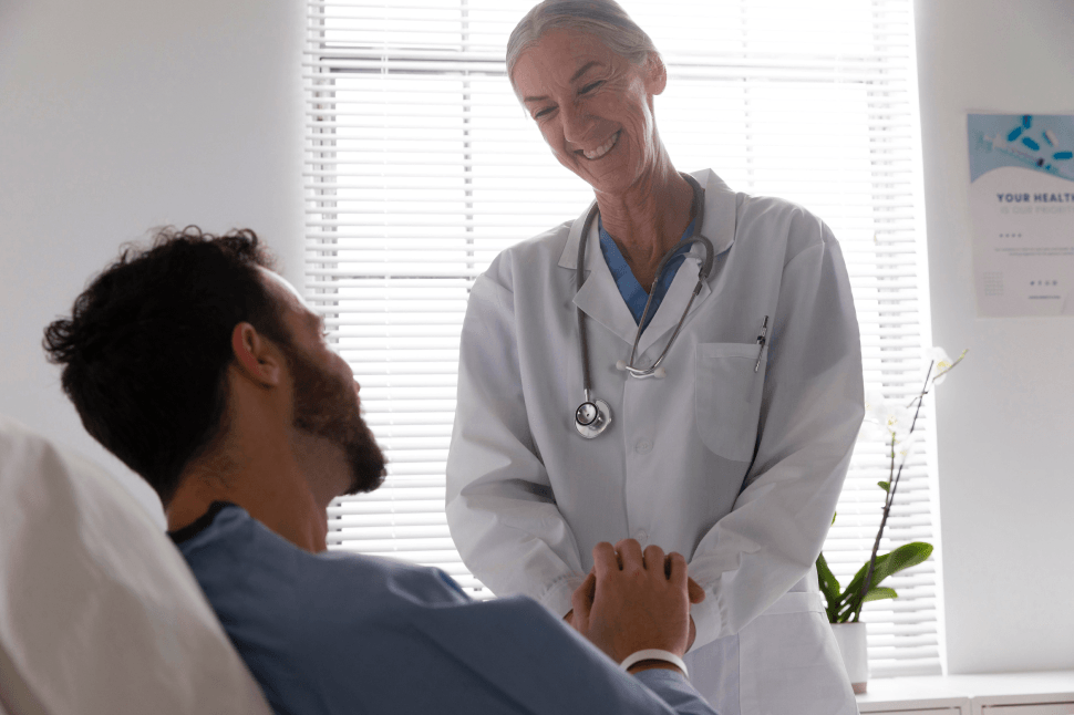 A smiling doctor reassuring a patient in a medical office about their Grade 1 Gynecomastia treatment.